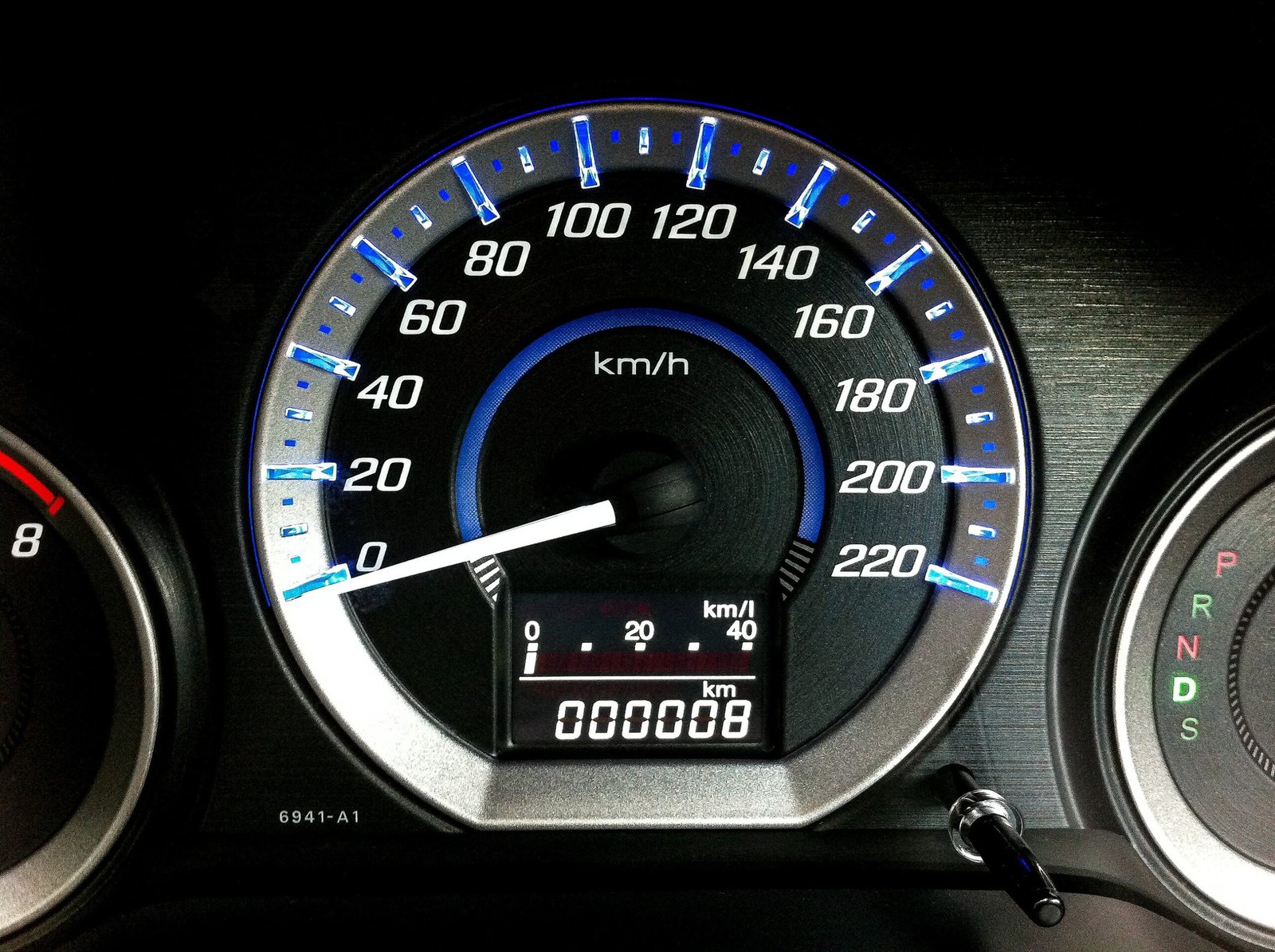 Car speedometer and odometer showing a new vehicle's mileage