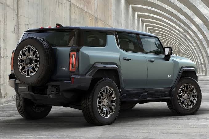 GMC Hummer EV SUV in grey, rear three-quarter view showing spare tire carrier and charge port area